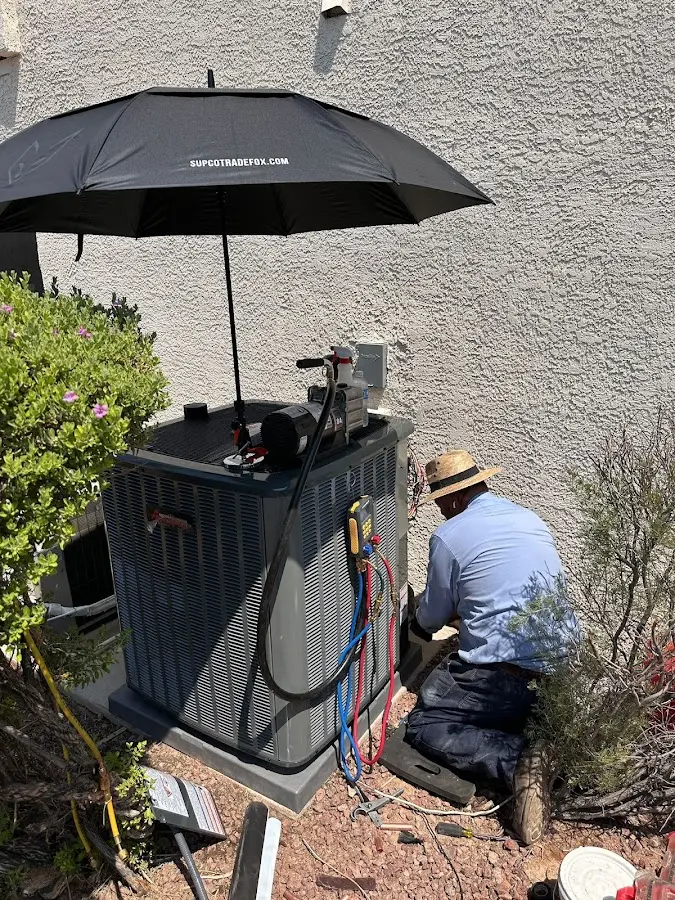 HVAC technician performing outdoor AC maintenance in Kingsville