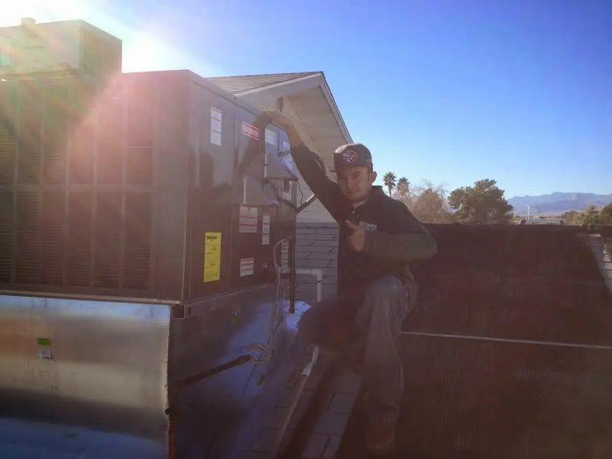 HVAC technician performing Boiler Repair on a rooftop unit in Kingsville